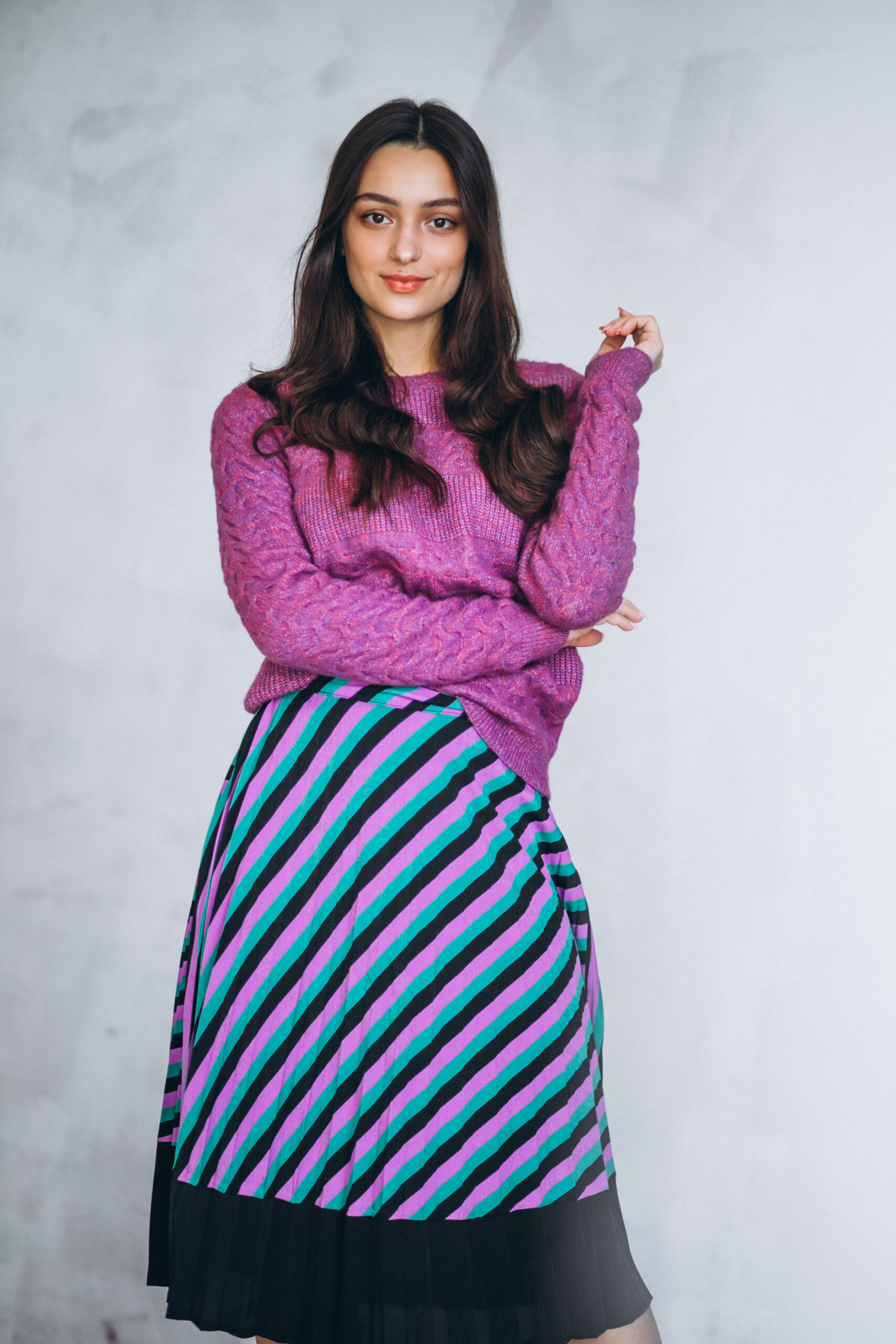 Home beautiful woman in a purple sweater and skirt in studio